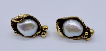 A pair of natural pearl earrings, the irregular shaped pearls nestled in unmarked gold (tested