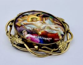 A large brooch set with a porcelain plaque, hand painted with the Crucifixion of Christ set in