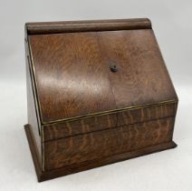 An antique oak stationary box with with two doors opening to reveal a fitted interior with waterfall