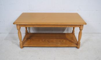 A light oak rectangular coffee table, raised on turned legs - length 100cm, depth 50cm, height 46cm