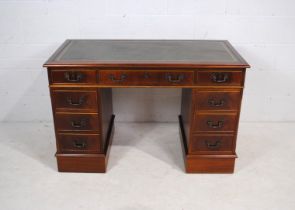 A mahogany kneehole desk, with green leather inset top and eight drawers - length 121cm, depth 62cm,