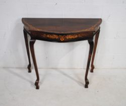 A Victorian style inlaid rosewood demi-lune table, raised on tapering cabriole legs with squared