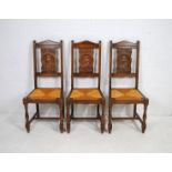 A set of six French Breton oak chairs, with carved panels depicting various characters, with drop-in