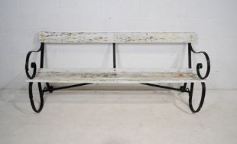 A weathered wrought iron garden bench, with white painted wooden slatted seat - length 181cm