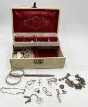 A collection of costume and silver jewellery including charm bracelet, silver hinged bracelets,