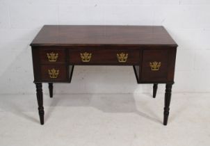 An antique mahogany ladies writing desk, with four drawers, raised on turned reeded legs- length