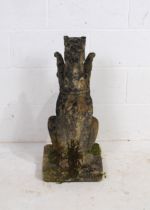 A weathered reconstituted stone garden figure in the form of a griffin - height 73cm