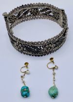 An Eastern silver filigree hinged bangle along with a pair of 9ct gold earrings set with turquoise