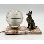 An Art Deco lamp with seated dog and globular shade on marble base