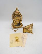 An Eluxa clock with accompanying wall bracket, key and paperwork - clock height 32cm