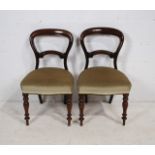A pair of Victorian mahogany balloon-back chairs, with upholstered seats and carved decoration,