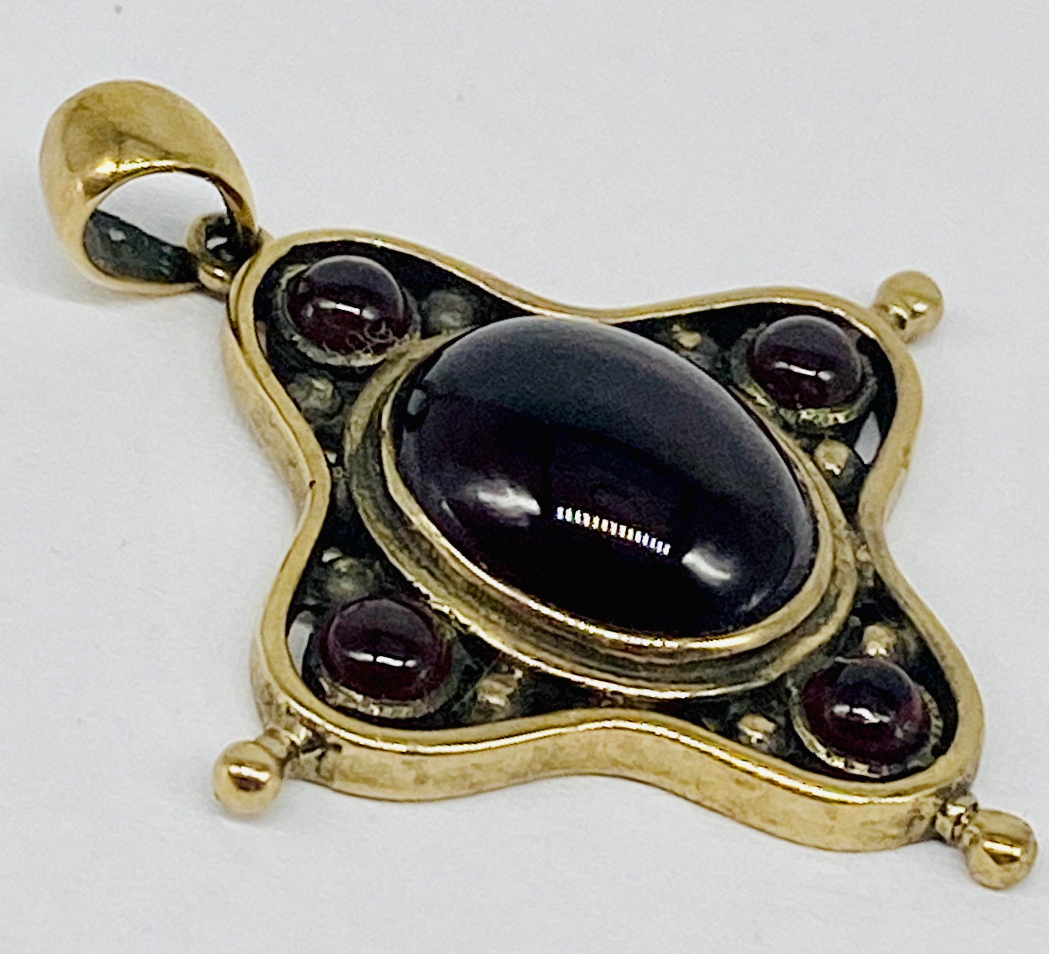An antique 9ct gold pendant set with cabochon garnets