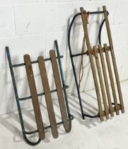 Two vintage sledges/toboggans with wooden seat on metal runners