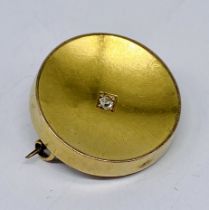 An unmarked 15ct gold mourning brooch set with a diamond, compartment for lock of hair to reverse