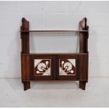 A turn of the century mahogany small wall hanging cupboard, with Mintons tiled doors and pierced