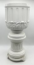 A large white oriental ginger jar along with a white urn on stand
