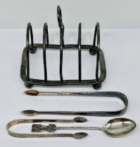 Two pairs of hallmarked silver Georgian sugar tongs, a silver spoon and a silver plated toast