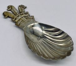 A hallmarked silver caddy spoon with fleur de lis decoration