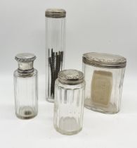 Three hallmarked silver dressing table pots along with a silver topped scent bottle