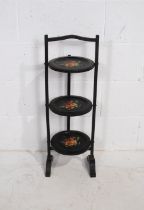 A Victorian ebonised cake stand, with hand painted floral decoration