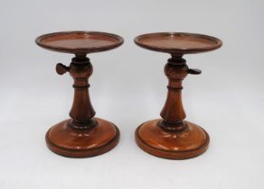 A pair of early 19th Century adjustable fruitwood candle stands - diameter 15cm, height 20cm (