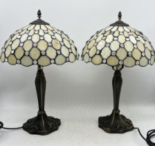 A pair of table lamps in the Tiffany style - damage to one shade as shown - height 56cm