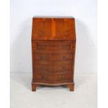 A yew wood serpentine-fronted bureau of small proportions, with four drawers, raised on bracket feet