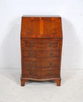 A yew wood serpentine-fronted bureau of small proportions, with four drawers, raised on bracket feet