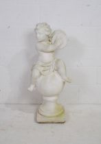 A white painted reconstituted stone garden figure of a cherub playing cymbals upon a ball and plinth