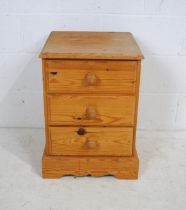 A pine bedside chest of three drawers - length 43cm, depth 43cm, height 61.5cm