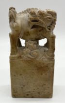 A Chinese carved soapstone Qilin figure with etched detail to base