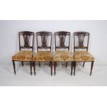 A set of four Edwardian inlaid mahogany upholstered dining chairs, with carved decoration, raised on