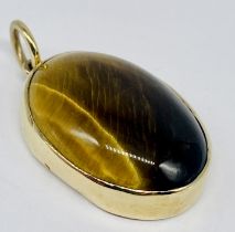 An unmarked gold pendant set with tigers eye