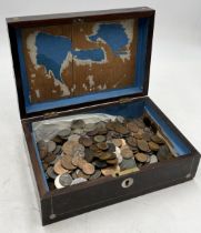 A collection of various coinage contained within inlaid wooden box