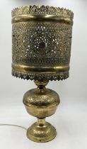 An Eastern brass table lamp with pierced decoration to shade and animal motif's to base - height