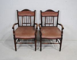 A pair of upholstered oak carver chairs, with carved detailing, raised on tapering legs