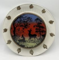 A vintage wall light with coloured silhouette landscape showing deer resting