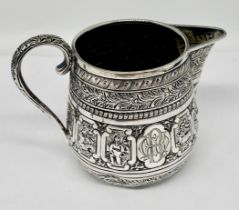 A Victorian hallmarked silver cream jug decorated with the signs of the zodiac