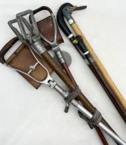 A collection of shooting and walking sticks with carved duck head handles