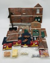 A small collection of G Scale model railway accessories including a building, signal, several