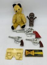 A vintage small teddy bear, along with three toy guns, Kewpie rubber doll and 3D Vista Screen with