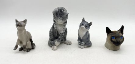 Three Royal Copenhagen cats model numbers 340, 1803 and 2308 along with a Siamese cat of similar