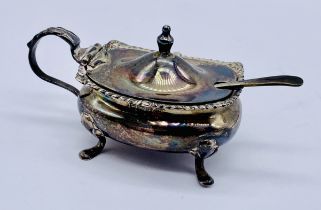 A hallmarked silver mustard pot and spoon with blue glass liner