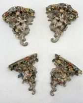 A collection of four continental wall sconces decorated with cherub and floral reliefs