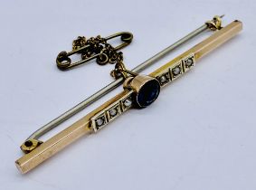 A 9ct gold bar brooch set with a blue stone flanked by seed pearls, pin not gold, total weight 2.8g