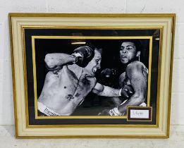 A framed large boxing picture of Sir Henry Cooper fighting Muhammad Ali which includes an original