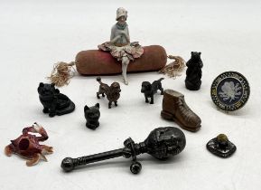 A collection of interesting items including pin cushions, bronze poodle, silver plated humpty dumpty