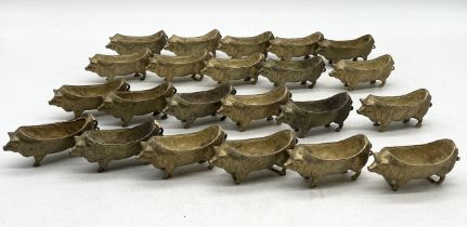 A collection of twenty two brass pig dishes/pin cushion frames