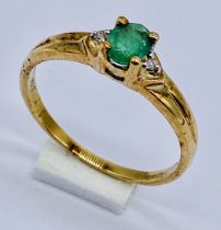 A 9ct gold emerald ring flanked by diamonds, size M 1/2