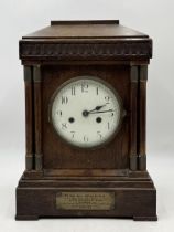 An early 20th century oak cased mantle clock with plaque reading "To Mr W.M. Spalding from the